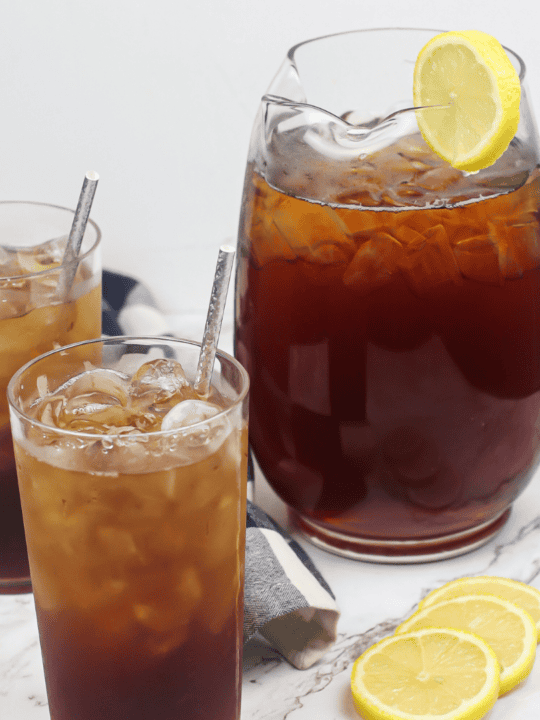 Cold Fruit Tea with a Ice in a Plastic Cup with a Lid on a Wooden