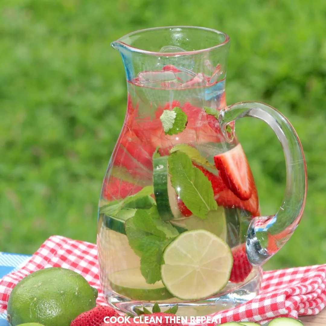 An image of a pitcher of water with fruit and herbs inside.