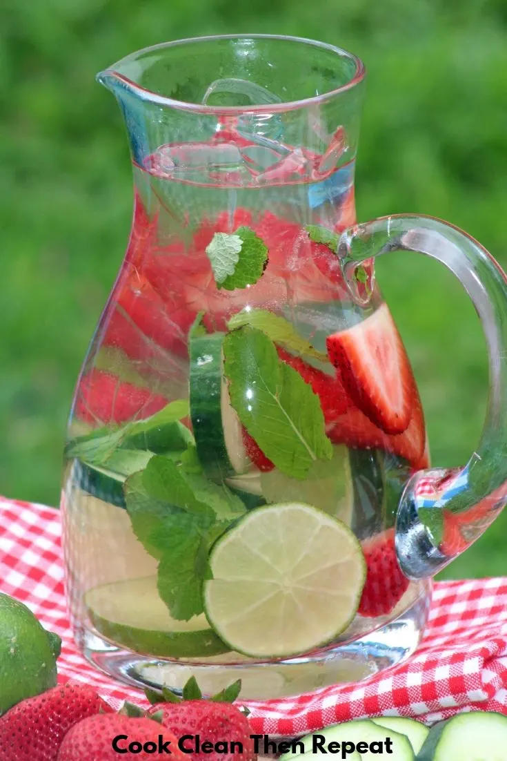 top of an image of a pitcher of water with fruit and herbs inside. 