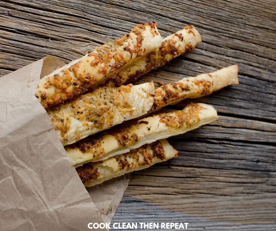 Breadsticks ready to eat wrapped in brown paper.