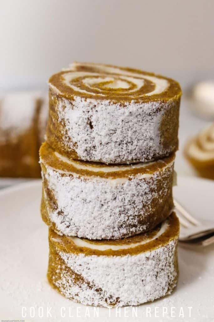 Stack of pumpkin roll slices on a plate ready to eat.