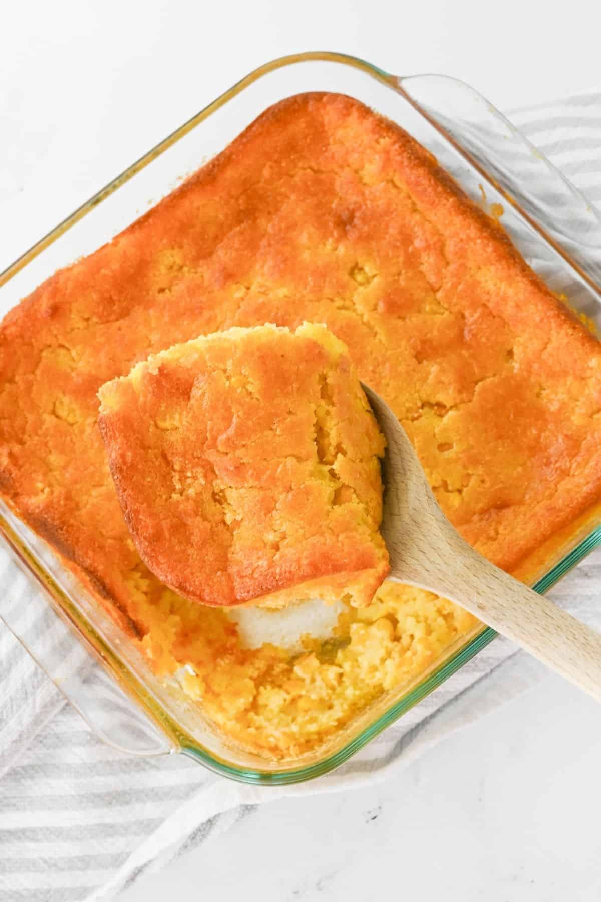 a slice of the cornbread casserole being scooped out after being baked.