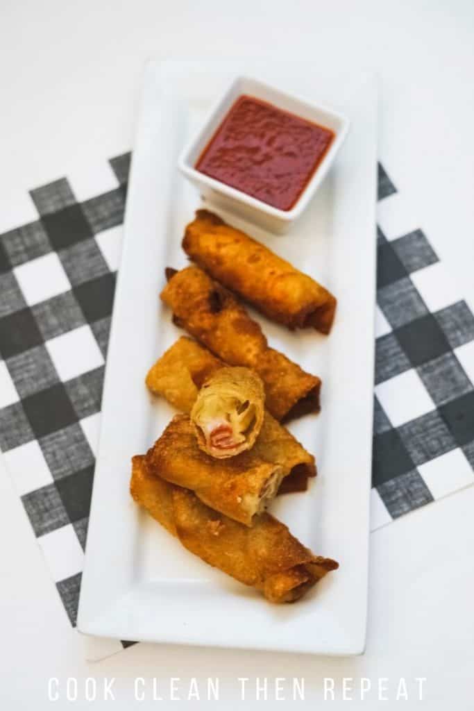 a view of one cut open pizza rollup with dipping sauce ready to eat.