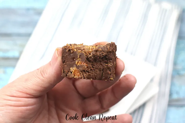 A bite of butterfinger fudge held up to show the camera.