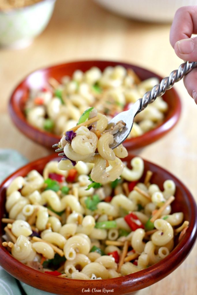 A bite of the pasta salad with chicken held up on a fork ready to be eaten. 