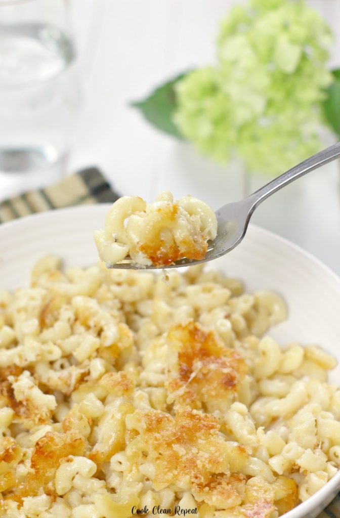 A bite of macaroni and cheese on a fork ready to be devoured. 