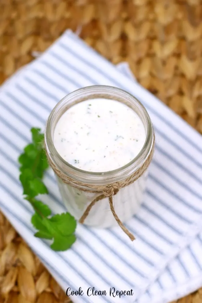 A top down look at a jar full of homemade ranch dressing. 