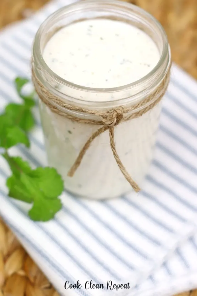 A close up view of a jar full of homemade ranch. 