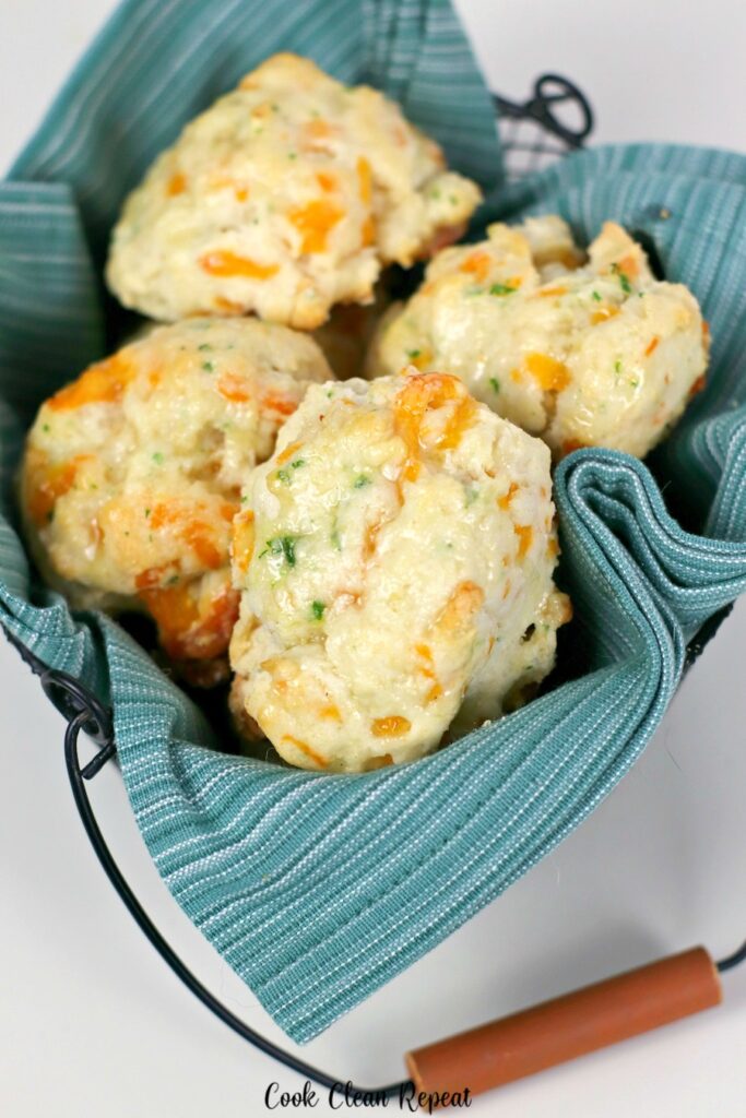 A basket full of the cheddar biscuits ready to be eaten. 