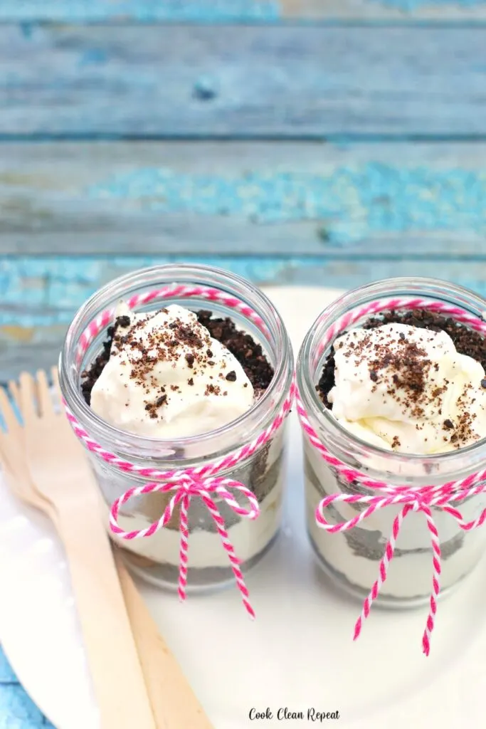 Here we see the layered no bake dessert cups tied up with a string and a wooden fork to eat them on the go! 