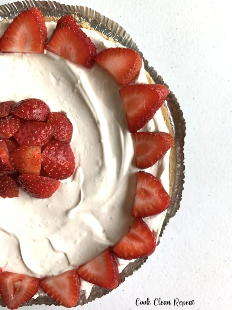 A full finished strawberry cheesecake ready to cut and serve.