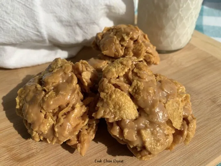 Featured image that shows the finished no bake peanut butter cookies on a cutting board with milk in the background ready to be enjoyed.