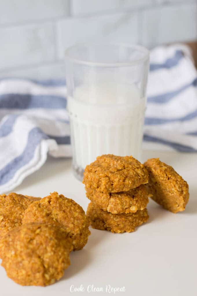 Un bicchiere di latte con i biscotti nella parte anteriore pronti per essere condivisi.