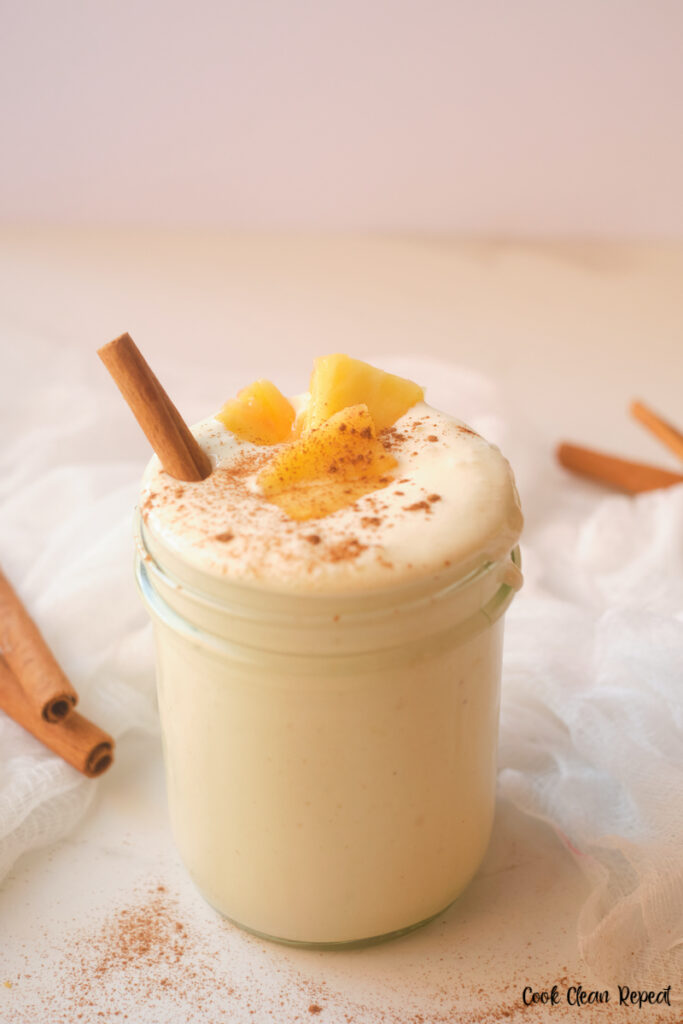 pineapple smoothie topped with cinnamon and pineapple chunks ready to drink. 