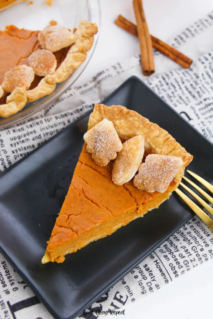 A top down view of a slice of baked pumpkin pie ready to eat. 