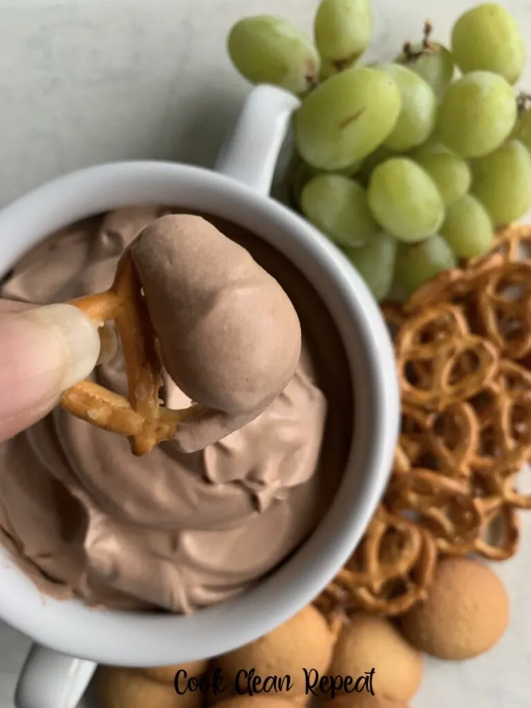 A scoop of the finished easy chocolate dip ready to eat on a pretzel. 