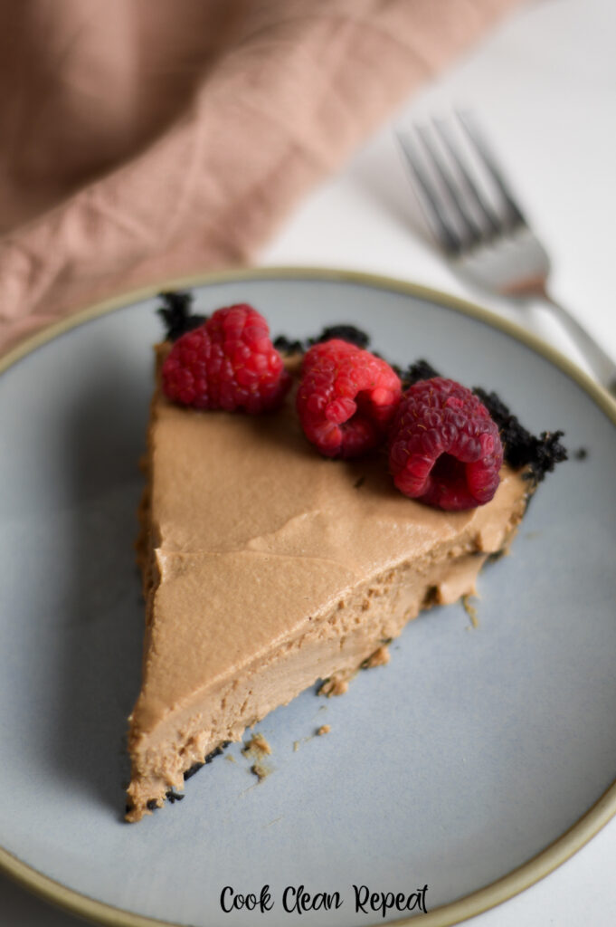 A top down look at a slice of cheesecake with raspberries. 
