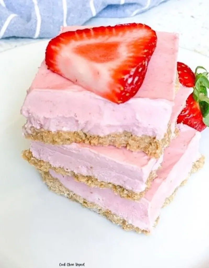 A stack of the finished strawberry cheesecake bars ready to eat.