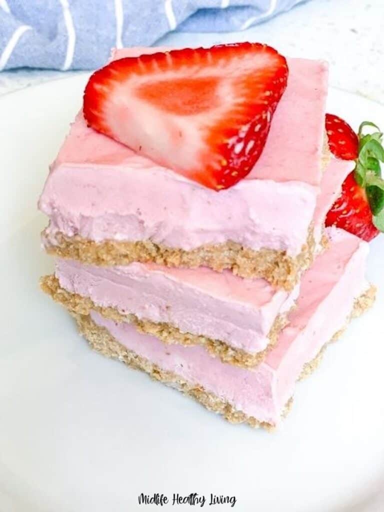 A stack of the finished strawberry cheesecake bars ready to eat.