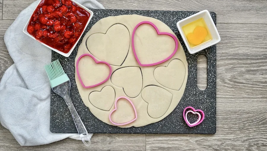Cutting out the hearts of pie crust. 