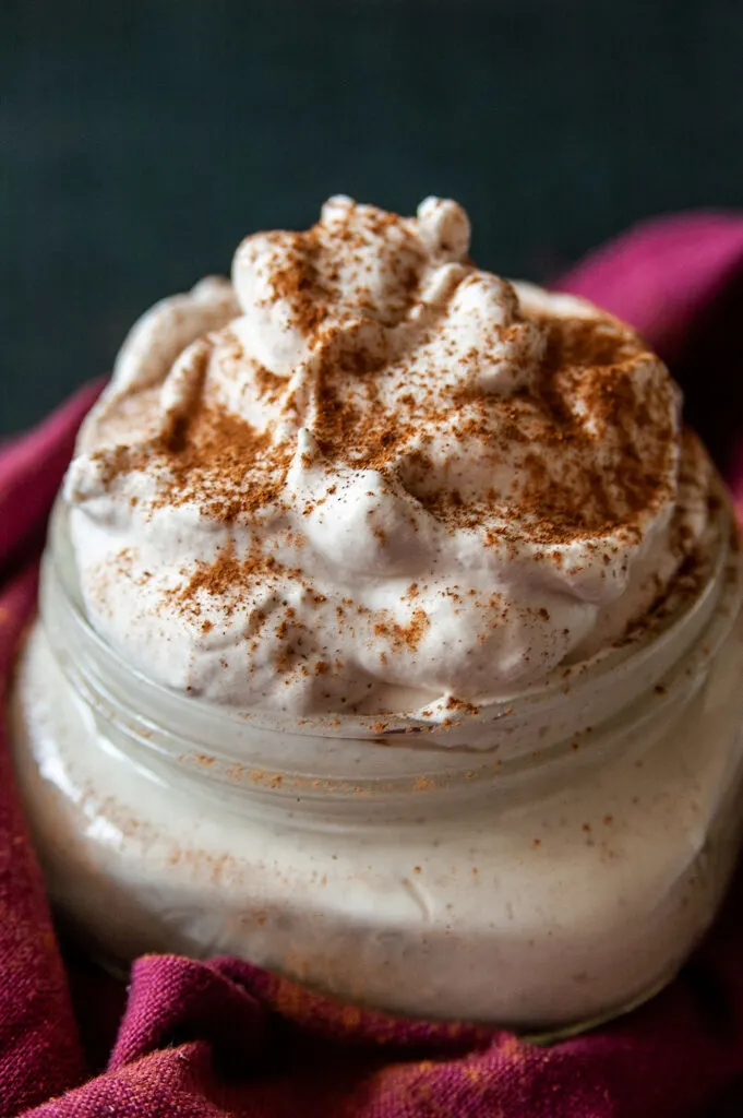 A look at the finished whipped cream topping with cinnamon in a jar ready to eat or store. 