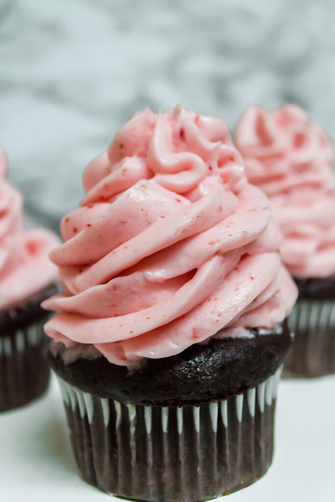 Cupcakes frosted with the finished strawberry frosting. 