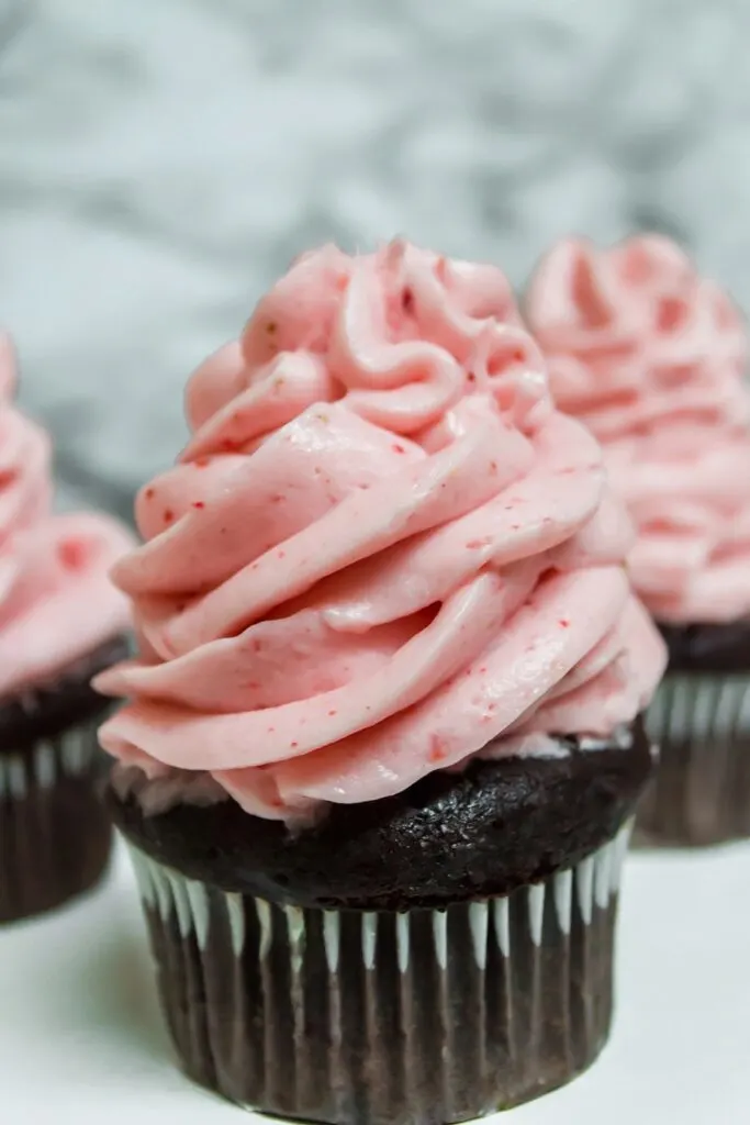 Cupcakes frosted with the finished strawberry frosting. 