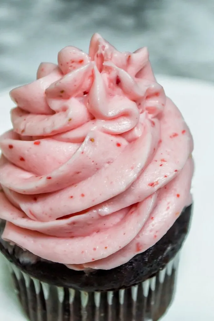 Finished strawberry frosting on a cupcake.