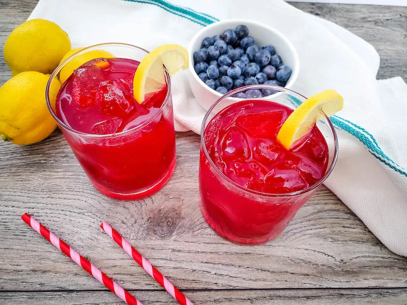 A look at a few glasses of blueberry lemonade ready to drink. 