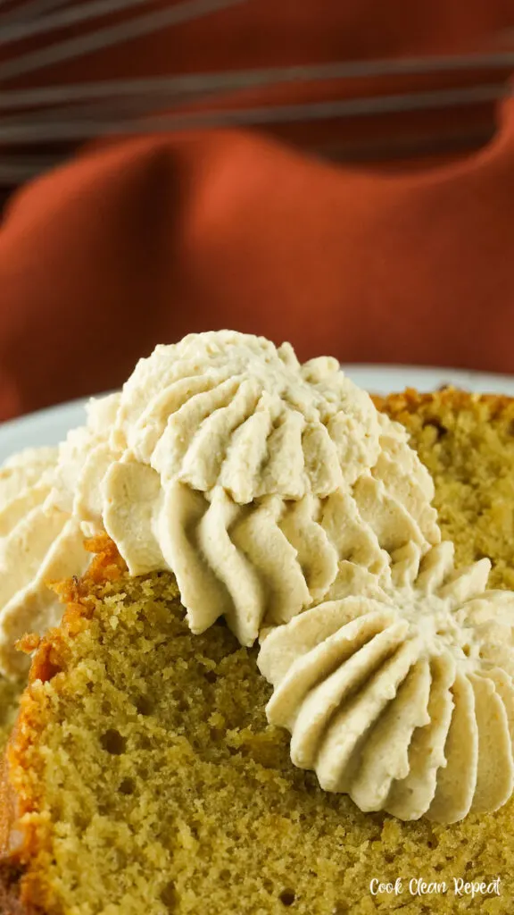 A close up of the finished whipped cream on a slice of pumpkin bread. 