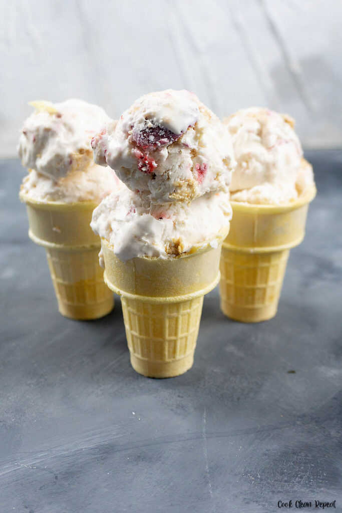 A look at the finished ice cream with strawberries and graham crackers scooped into cones ready to serve.