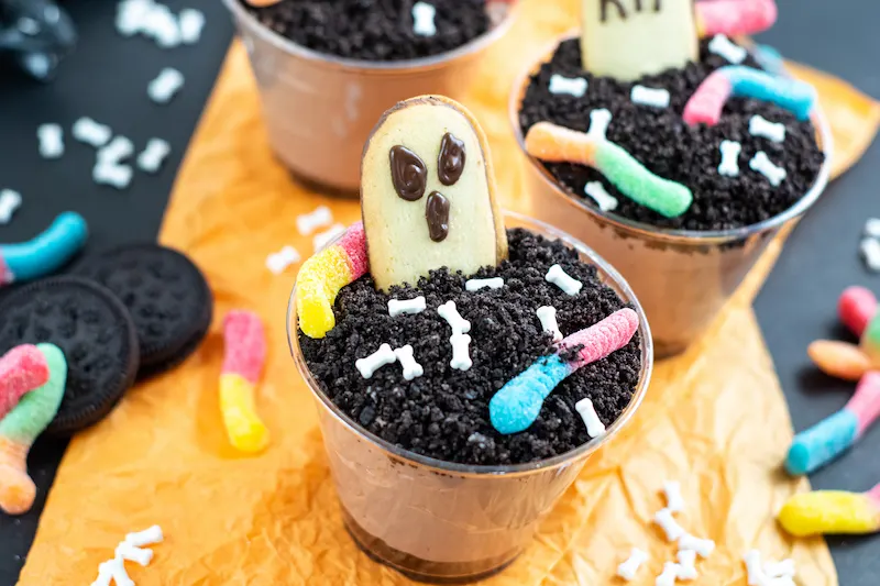 A side view featured image showing the finished halloween dirt pudding cups. 