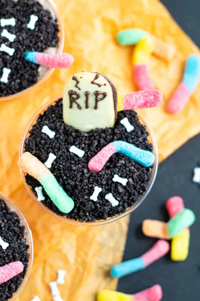 A top down look at the finished halloween dirt pudding cups with worms and gravestone ready to eat. 