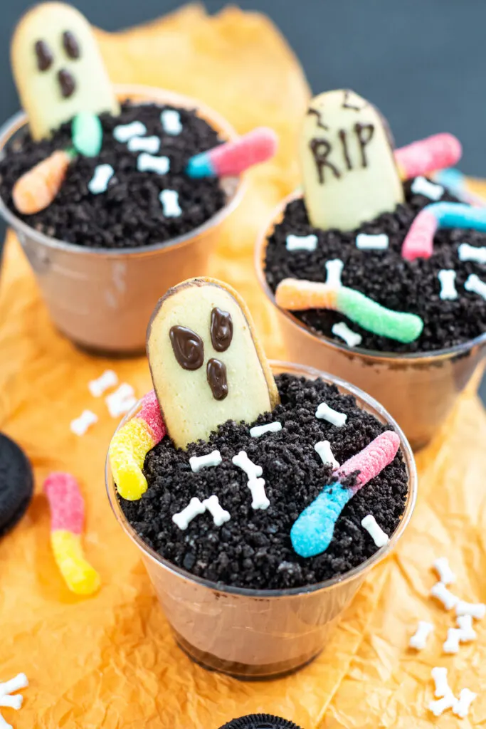 A variety of finished halloween dirt pudding dessert graveyard cups. 