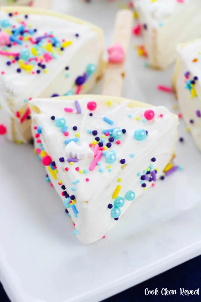 a close up of a finished slice of unicorn cheesecake on a stick ready to serve. 