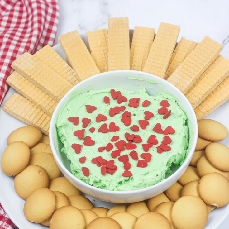 Featured image showing the finished grinch dip surrounded by cookies for dipping.