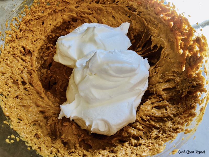 cool whip being added to the pumpkin mixture. 