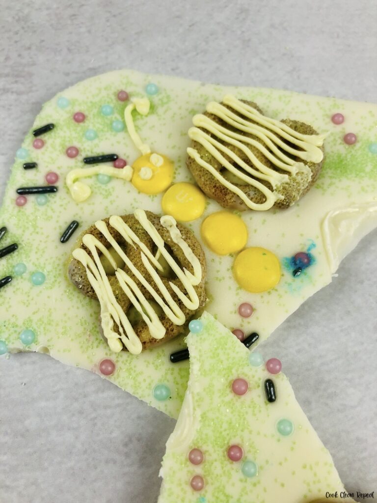 close up view of finished yellow butterfly on pretzel almond bark with m&ms