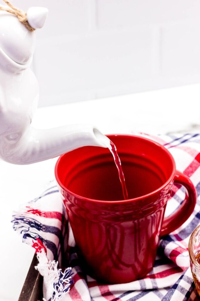 water being poured into a red mug