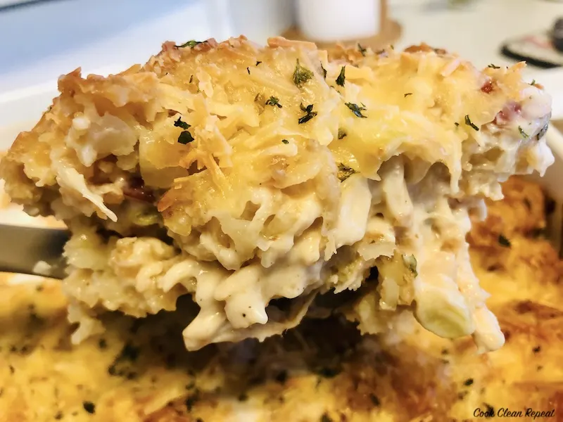 a scoop of the finished cheesy tater tot casserole ready to serve. 