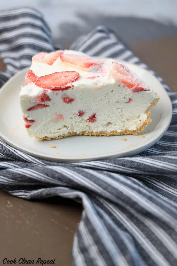 side view of a slice of strawberry cheesecake ice cream pie ready to serve