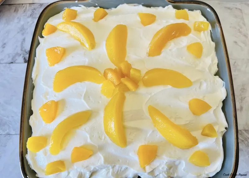 extra peaches on top decorating cheesecake. 