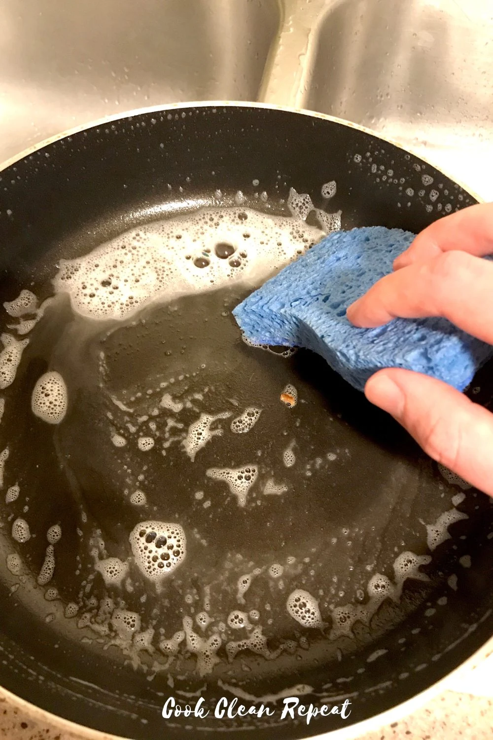 Hand scrubbing the baking pan with soap and water