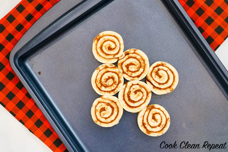 arranging the cinnamon rolls on the cookie sheet