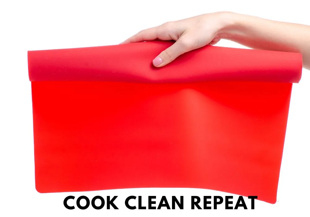 person holding out a red silicone baking mat