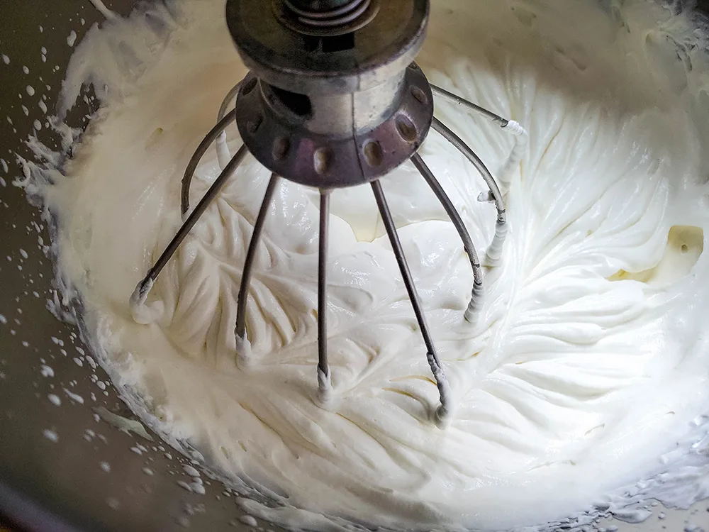 An overhead view of a stand mixer mixing together ingredients