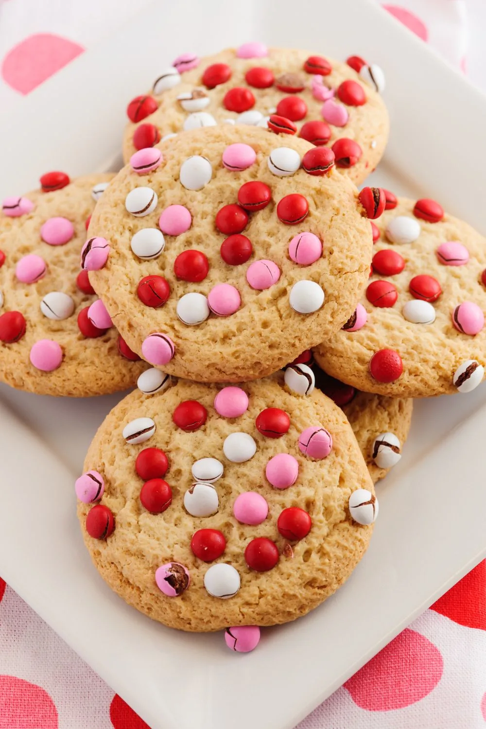 a plate of cookies with red, pink, and white candy on top