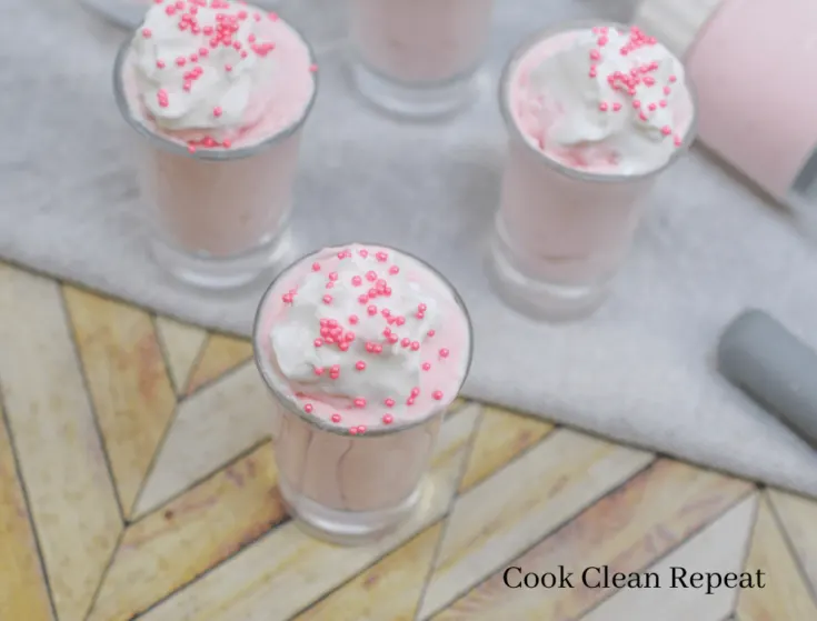 strawberry cheesecake dessert with whipped cream and sprinkles
