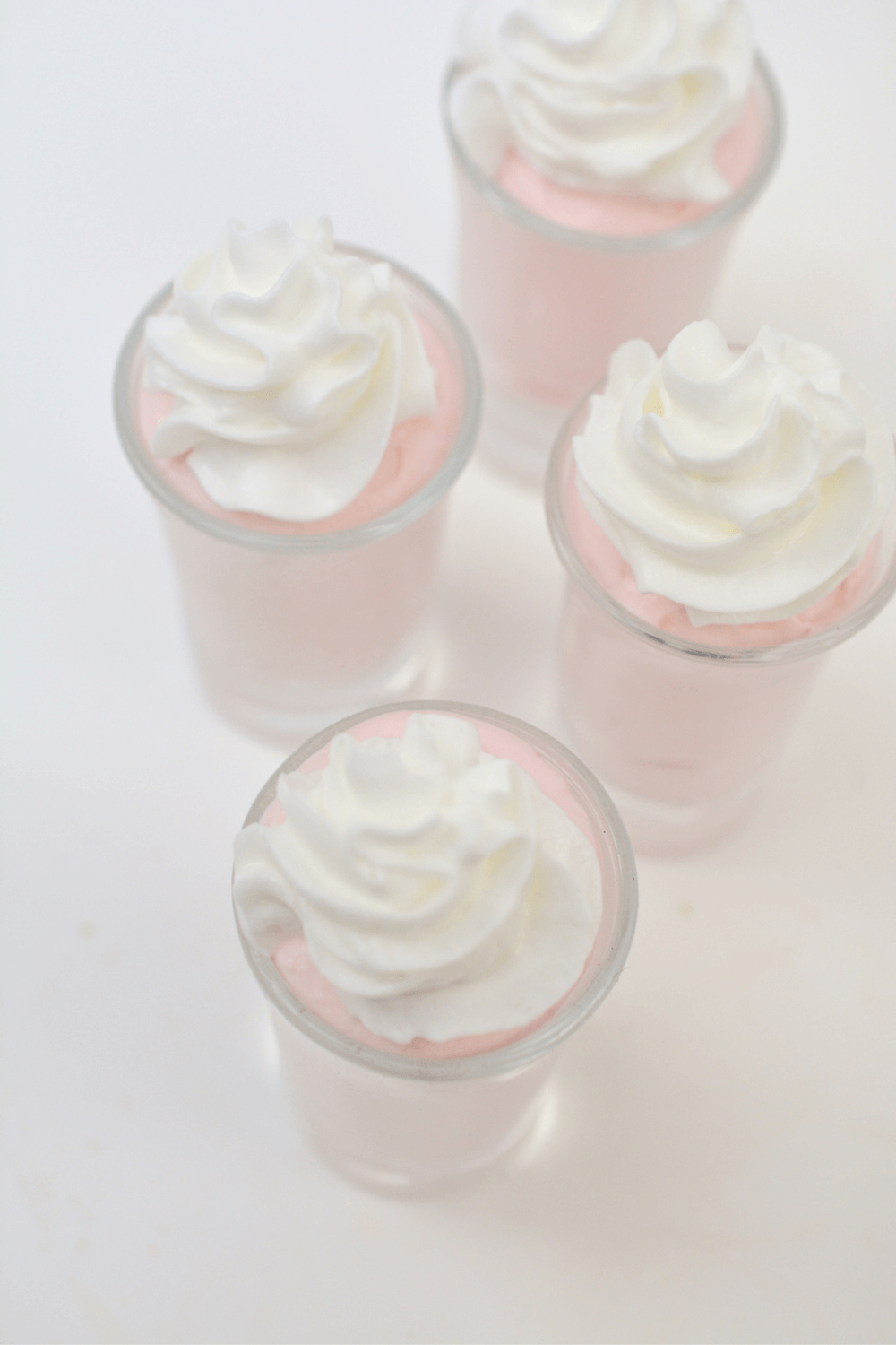 strawberry cheesecake with whipped cream in shot glasses