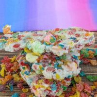 fruity pebble rainbow bark stacked with a pink and purple background